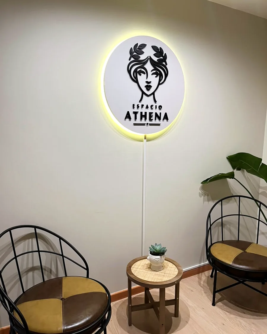 Recepción de Espacio Athena en Providencia, con el logo iluminado y sillones de espera
